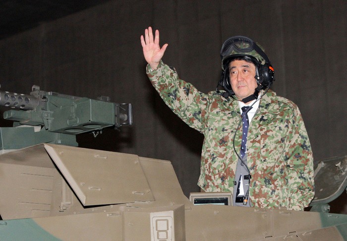 Thủ tướng Nhật Bản Shinzo Abe mặc quân phục trên xe tăng được Pháp chế văn báo tuyên truyền là ông có hô “Thiên hoàng vạn tuế”